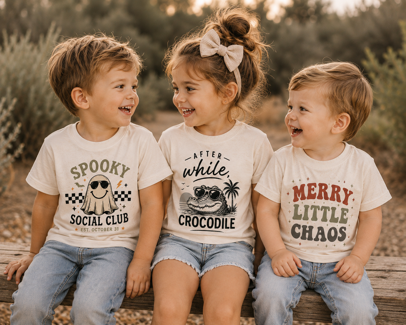 Three boutique tees hanging in a warm nursery setting